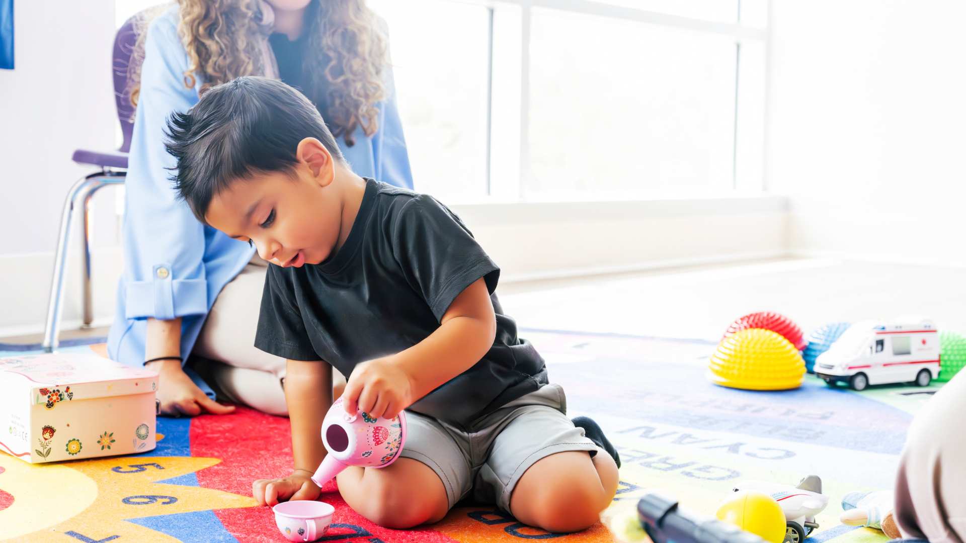 A child and therapist seated together during an ABA learning moment