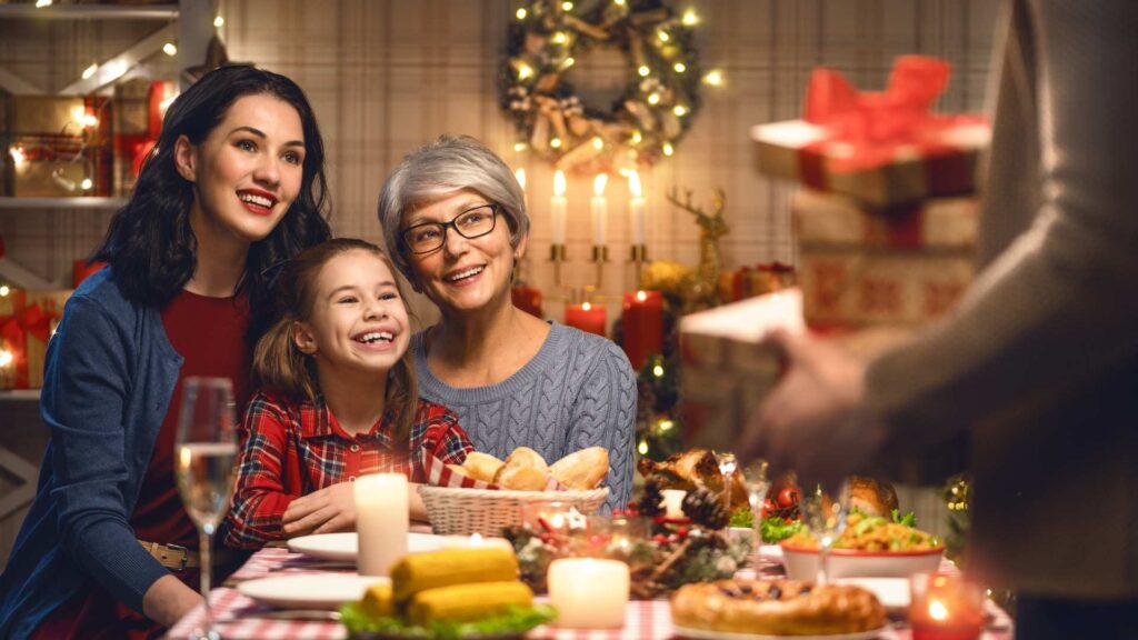 A family sitting at a dinner table during a calm, autism‑friendly holiday gathering with soft lights and a warm setting