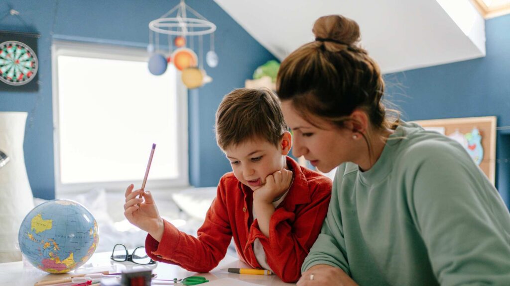 A quiet study scene with a parent guiding a child, representing autism and homeschooling