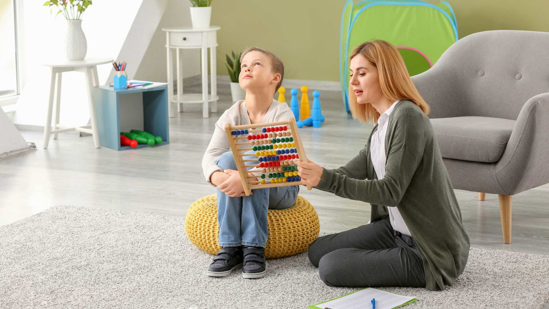 A young child looking away while an adult engages them, used to show early autism behaviors