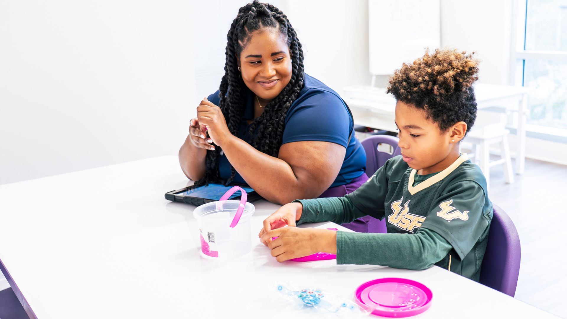 ABA therapist guiding a child through a play-based therapy session using positive reinforcement.