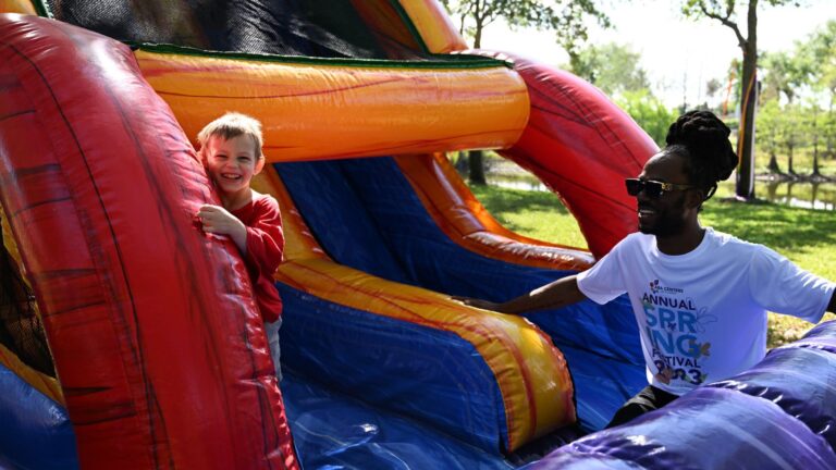 ABAFL Social Media. A client smiles on a slide with a behavior technician.