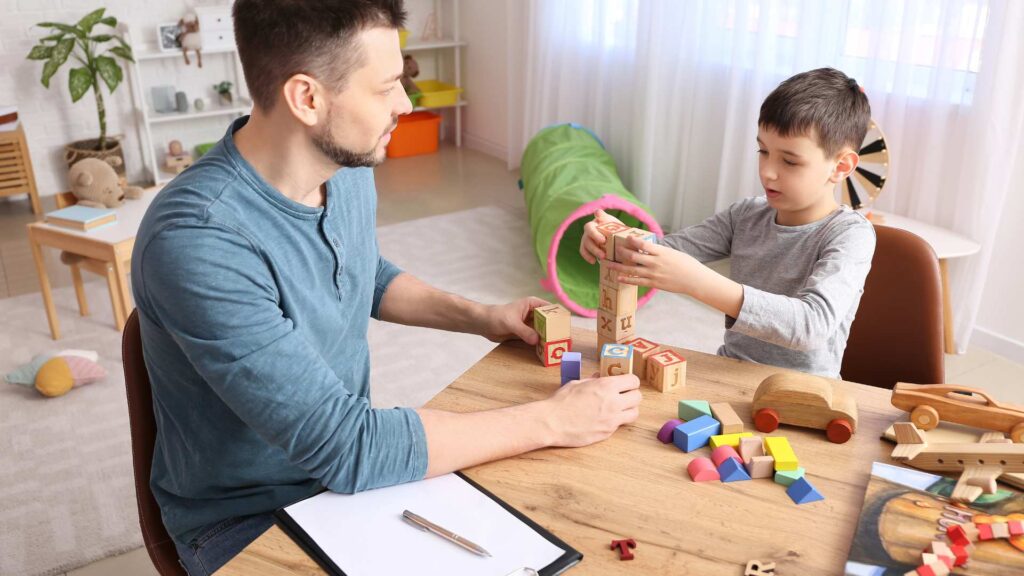 Adult and child engaging in a play‑based activity to model gentle guidance and compliance in autism