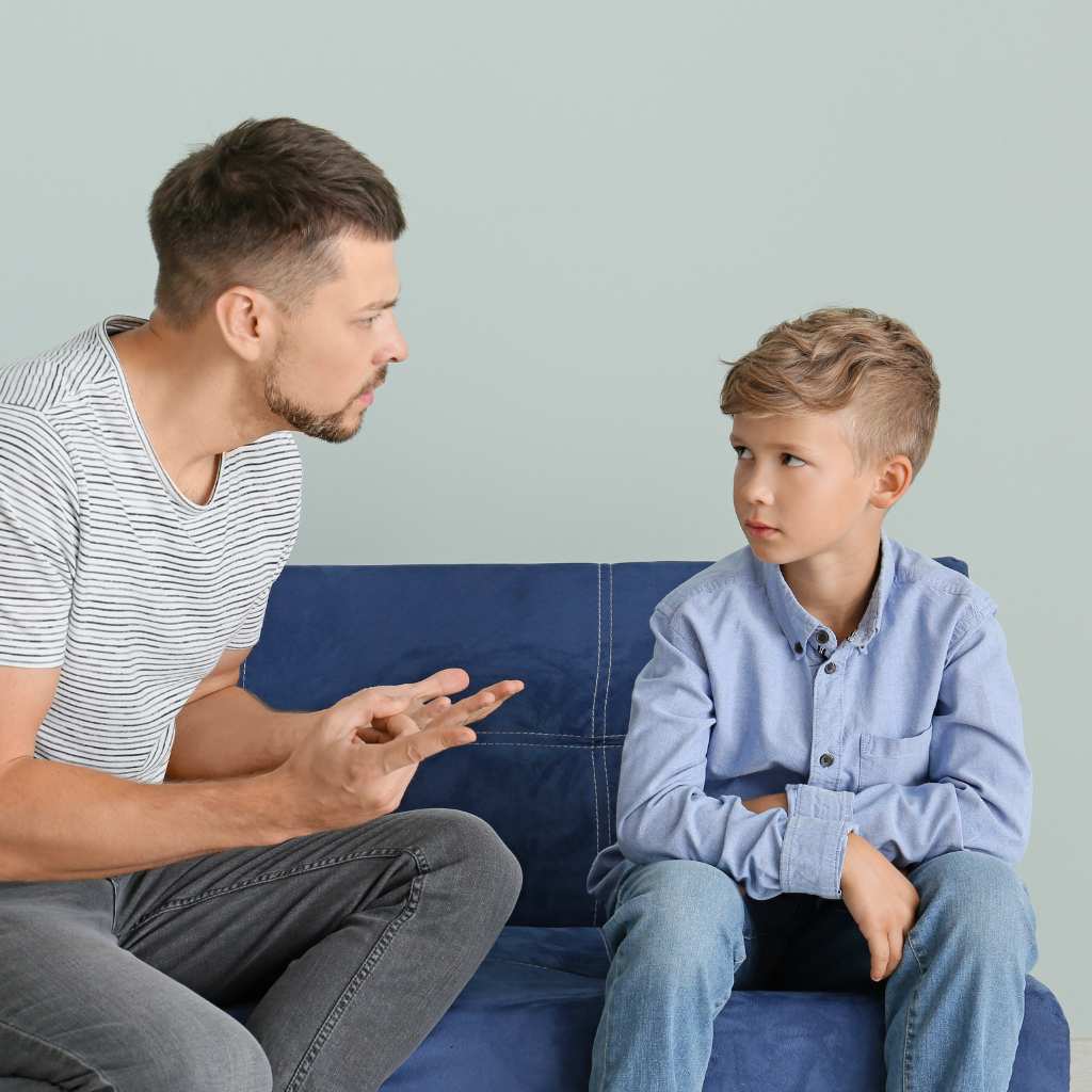 Adult and child sitting together as the child shows reluctance to engage
