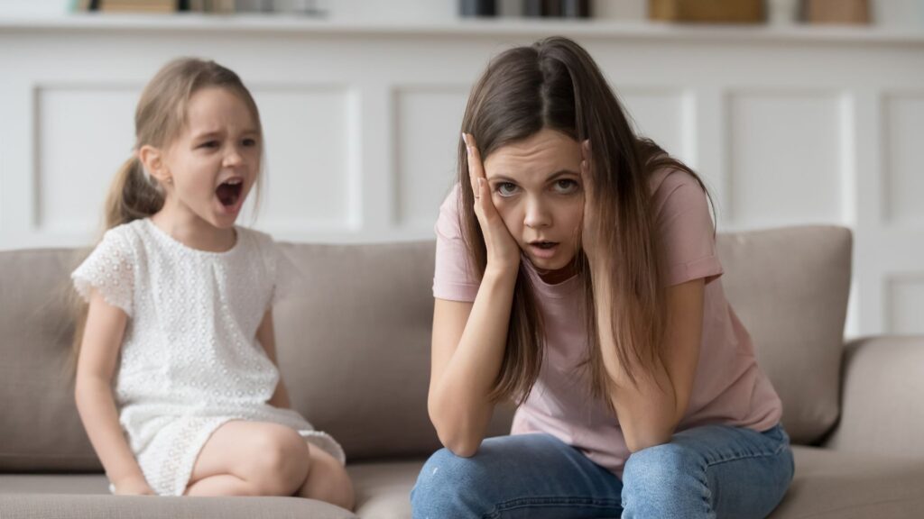 Autism tantrums. A child tantrums as their mother looks distressed.