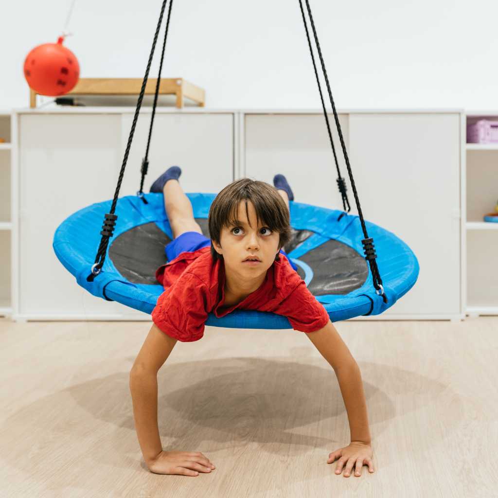 Child engaging in sensory play on swing – illustrating autism and a narrowed window of tolerance.