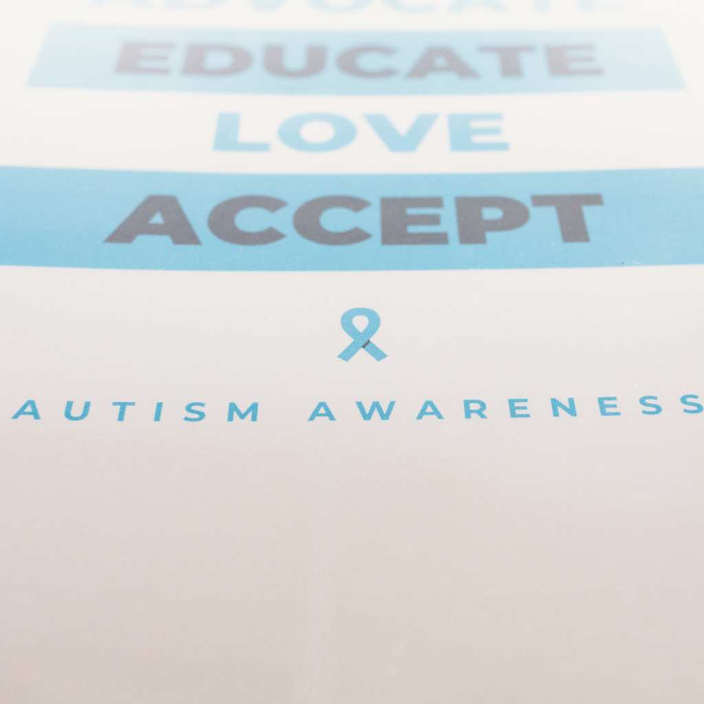Autism awareness poster with the words Advocate, Educate, Love, and Accept alongside a blue awareness ribbon