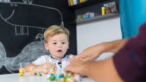 Child participating in ABA therapy for toddlers with a therapist using toys to encourage communication and engagement