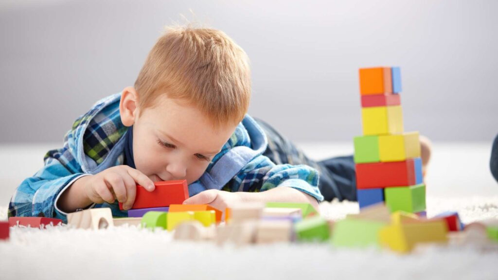 Child playing quietly with blocks on the floor — Signs of Autism in 3-Year-Olds
