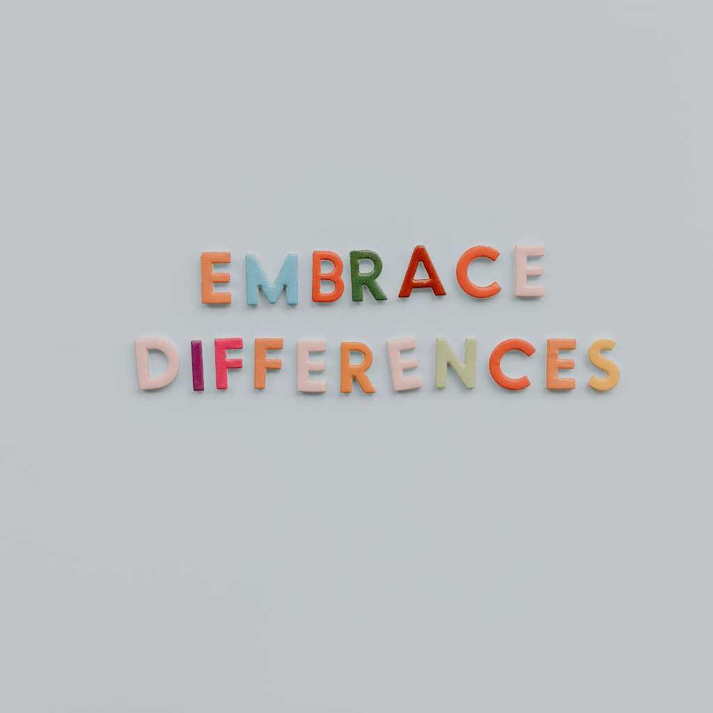 Colorful felt letters spelling 'Embrace Differences' on a light gray surface