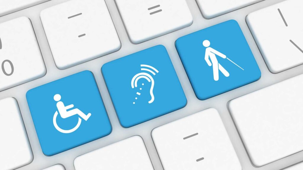 Un teclado con tres teclas azules que destacan para celebrar el Día Mundial de Concienciación sobre la Accesibilidad. Uno con el símbolo de una silla de ruedas, otro con una oreja, otro con un hombre en un bastón.