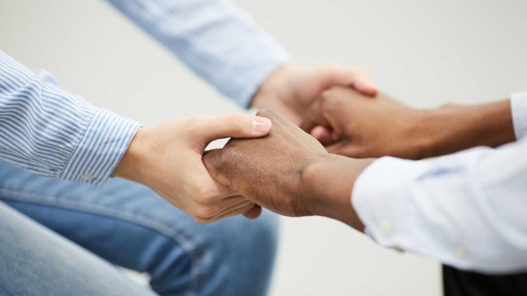 Empathy and autism: two individuals holding hands.