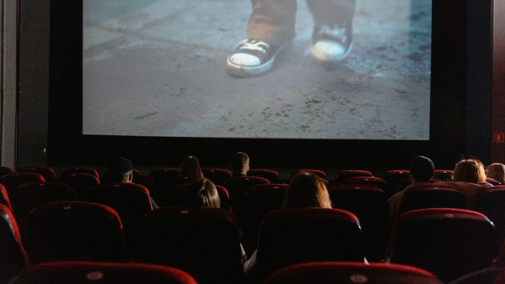 Famous parents: Darkened theater watching a child walk on a beach on the movie screen
