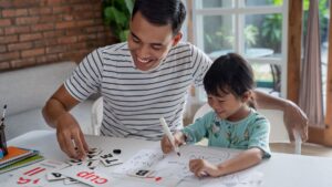 Father using ABA strategies for parents during a fun learning activity to build communication, literacy, and early learning skills at home.