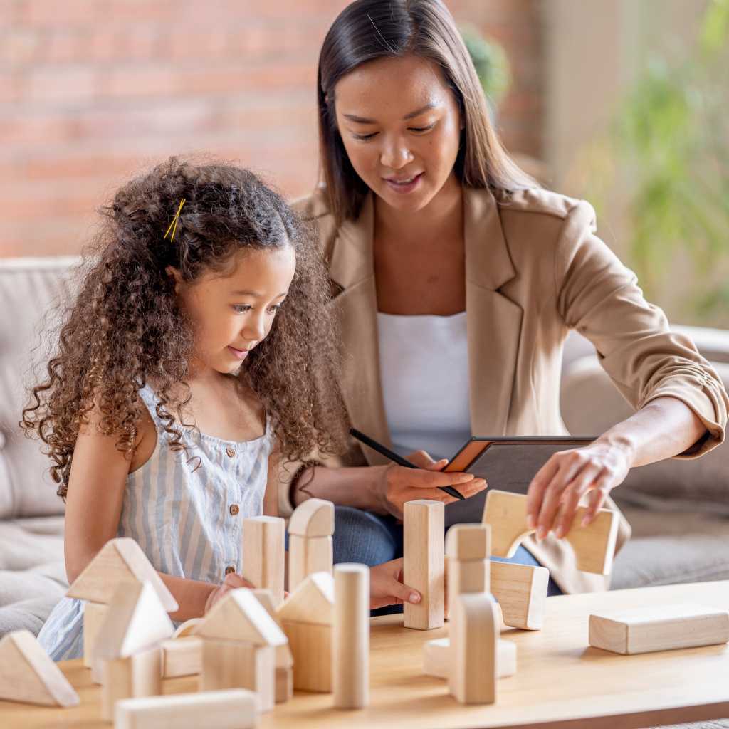 Therapist guiding a young girl through structured play therapy, demonstrating how ABA therapy supports children with level 1 autism.