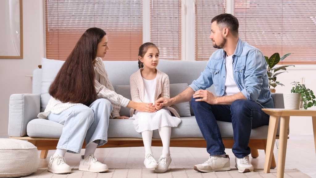 Parents sitting with their child in a calm home setting, demonstrating emotional support and regulation in autistic children’s nervous systems.