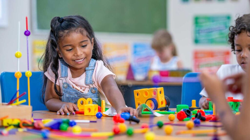Young girl engaging in creative play at school, symbolizing growth, confidence, and the importance of developing self-advocacy skills in children with autism.