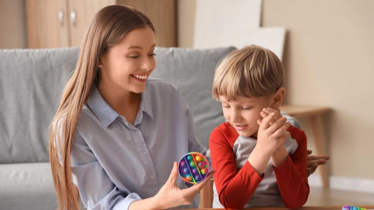 Therapist supporting a child with Level 2 autism using a sensory toy during a structured interaction