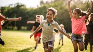 Children playing outdoors, illustrating regulation and movement in the nervous systems of autistic children through physical activity and social engagement.