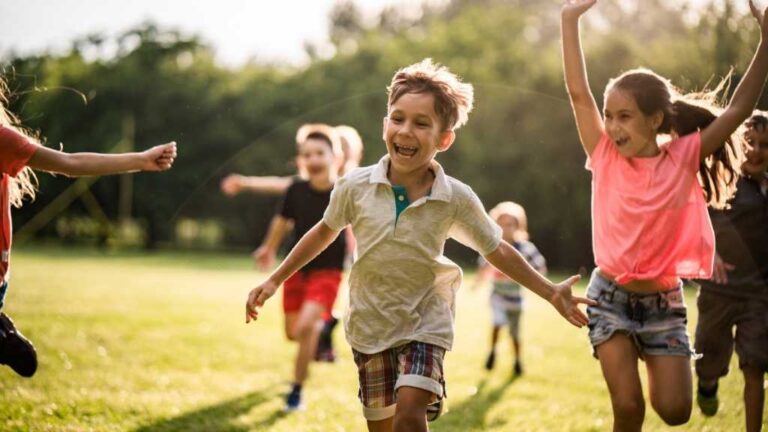 Children playing outdoors, illustrating regulation and movement in the nervous systems of autistic children through physical activity and social engagement.