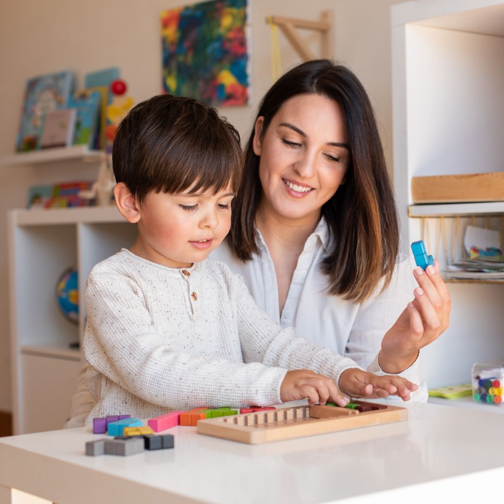 Parent using ABA therapy techniques at home to reinforce learning and communication skills through play.