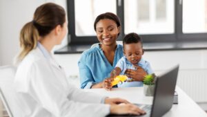 Pediatrician discussing therapies for autism with a parent during a child's developmental evaluation.