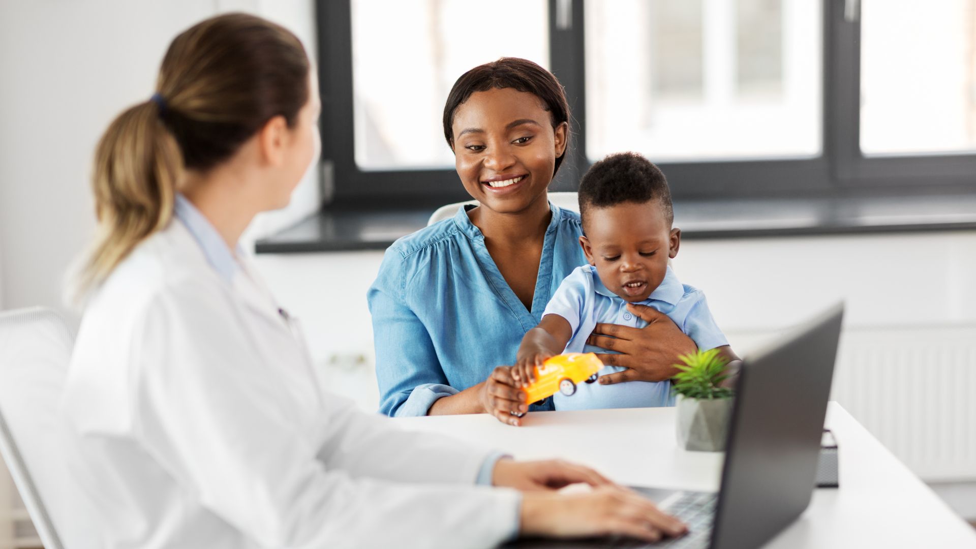 Pediatrician discussing therapies for autism with a parent during a child's developmental evaluation.