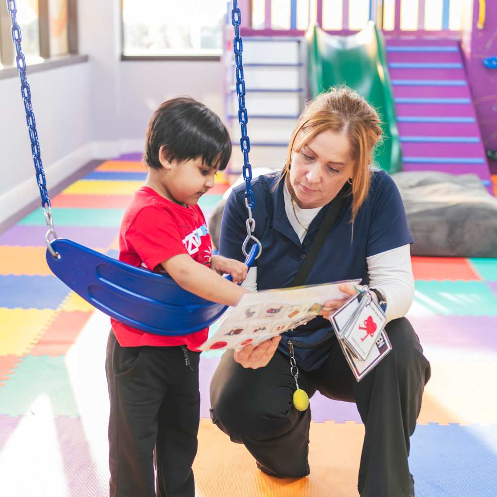 Therapist and child looking at picture symbols together during a communication activity