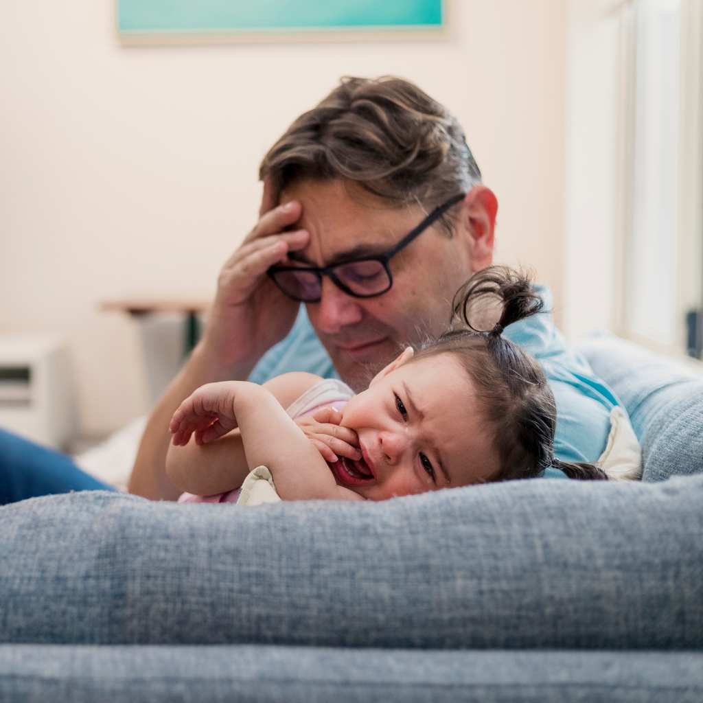 Toddler showing distress while her caregiver confort her