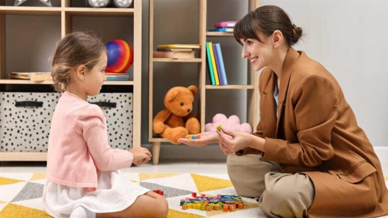 Therapist engaging with a young girl during an educational therapy session, representing early support and learning for children with level 1 autism.