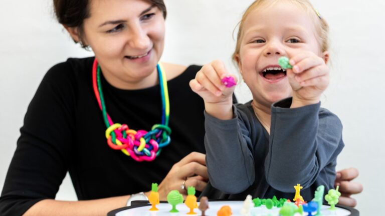 Woman and child play together with toys as part of autism support.