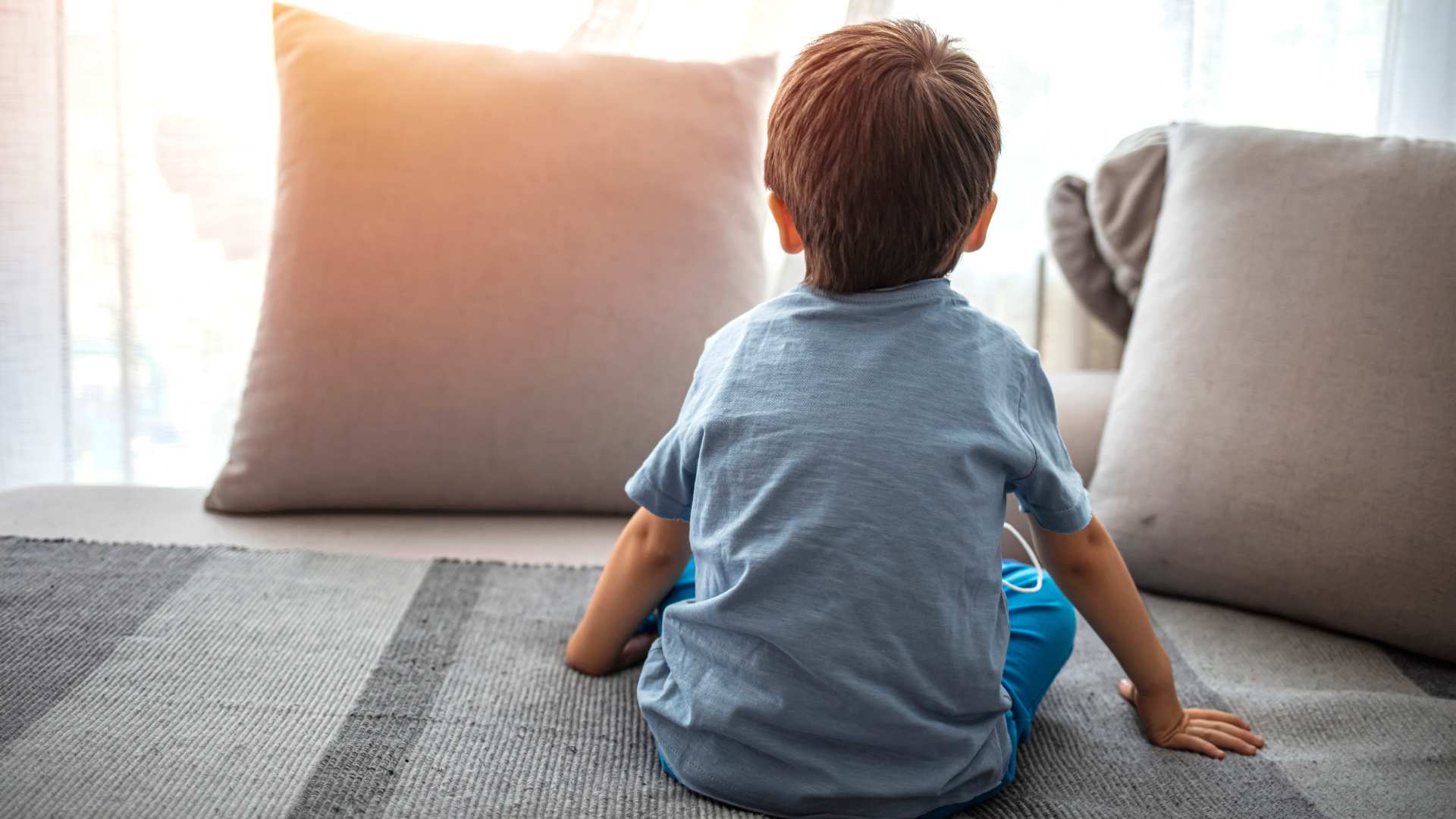 a toddler sitting in the couch showing signs of autism