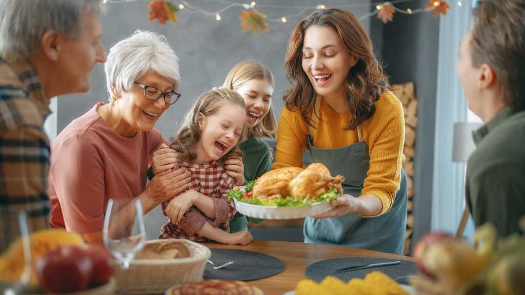 Family enjoying an autism-friendly Thanksgiving dinner together, smiling as they gather around the table with a golden roasted turkey.