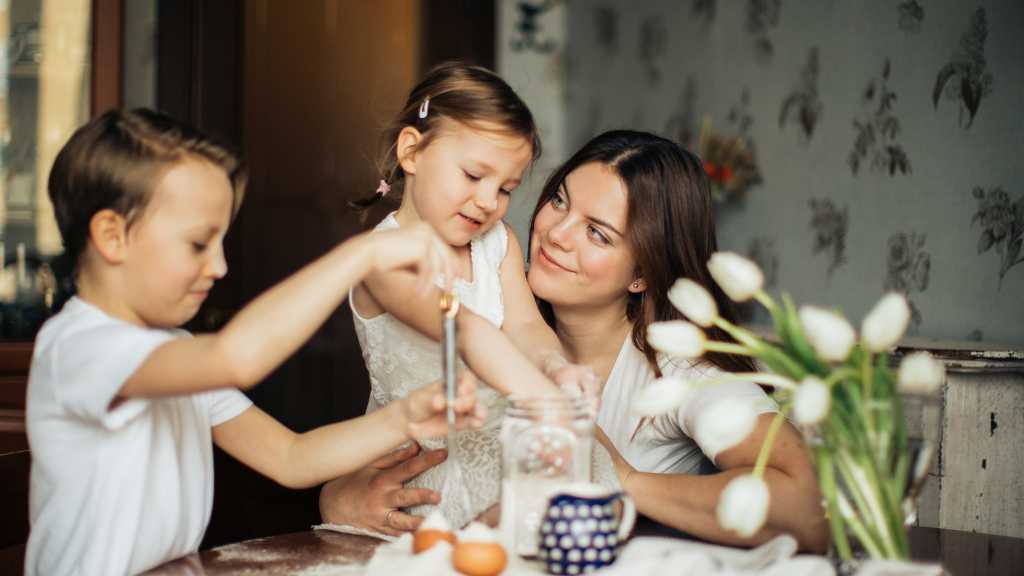 Parent supporting children as they make choices during a family baking activity